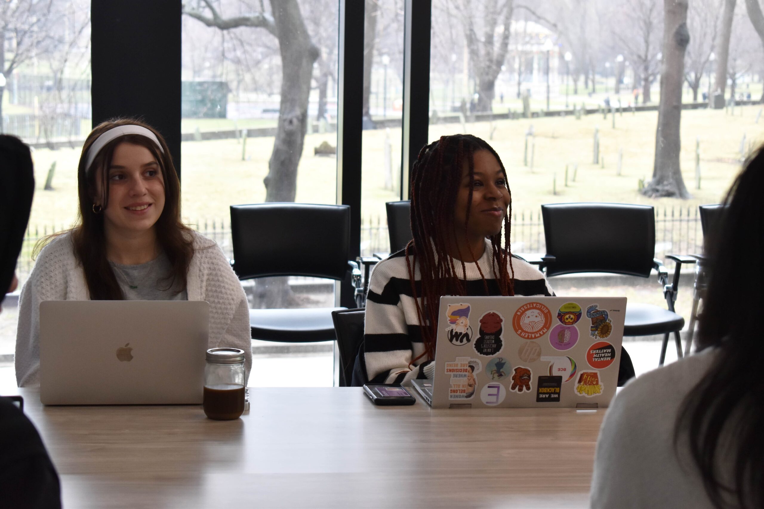 Two students sitting at a table with laptops