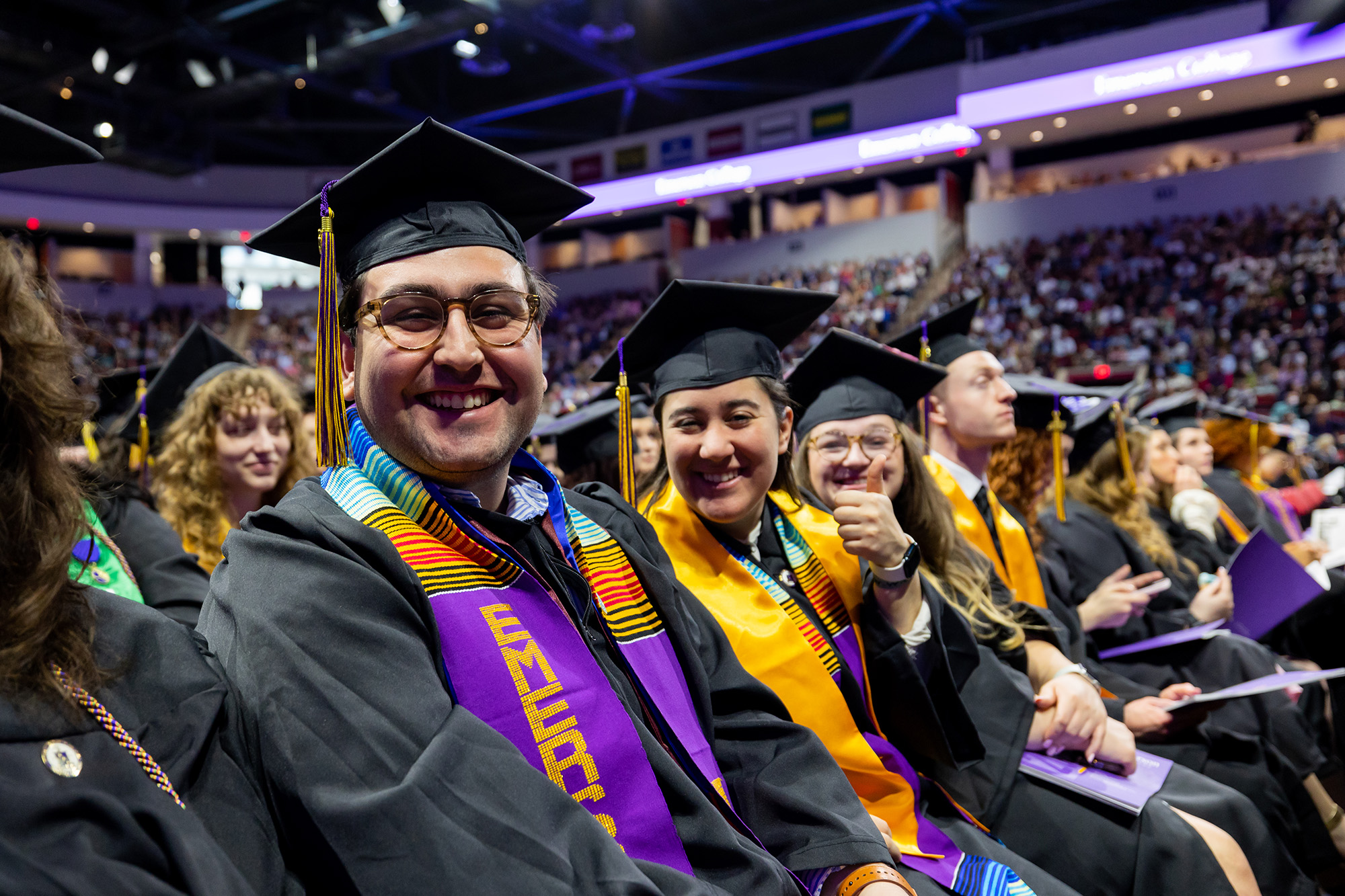 Three Emerson now-alums smiling at the camera at Commencement.
